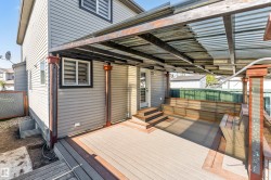 Covered outdoor deck featuring built-in bench seating, durable composite decking, and a corrugated metal roof - 