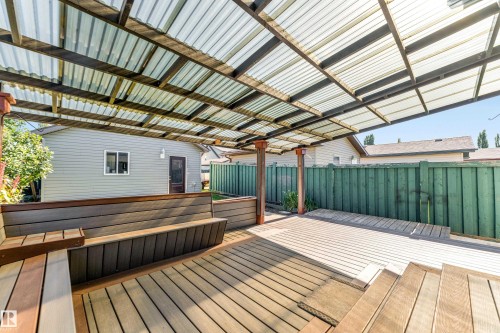 Outdoor covered deck featuring wood-finish decking, built-in benches, and a translucent corrugated roof - 1921 119A Street, Edmonton, AB - Outdoor With Deck Patio Veranda With Exterior