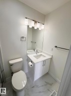 Bathroom featuring a white vanity with an integrated sink, polished chrome faucet, and white countertop - 