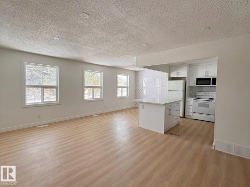 Open-concept living space featuring wood-finish flooring, recessed lighting, and multiple windows - 20 Hunt Road, Edmonton, AB - Indoor Photo Showing Kitchen