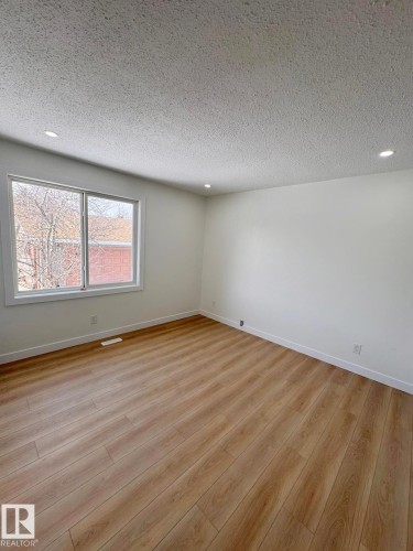 Spacious room featuring wood-finish flooring, white baseboards, and white walls - 20 Hunt Road, Edmonton, AB - Indoor Photo Showing Other Room