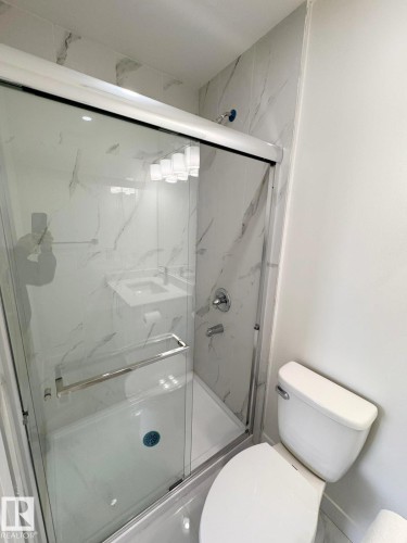 Contemporary bathroom featuring a glass-enclosed shower with white marble-look tile surround and chrome fixtures - 20 Hunt Road, Edmonton, AB - Indoor Photo Showing Bathroom