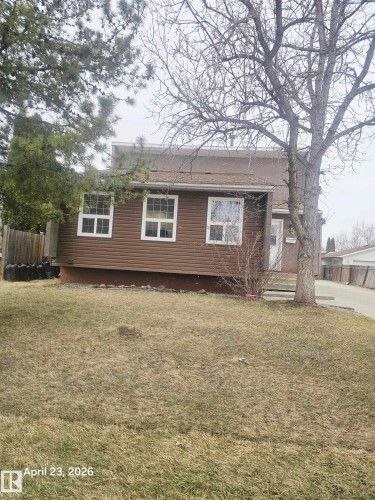 Brown horizontal siding exterior with white window frames and a sloped roofline - 20 Hunt Road, Edmonton, AB - Outdoor