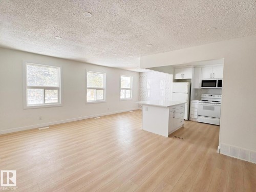 Open-concept living space featuring wood-finish flooring, recessed lighting, and multiple windows - 20 Hunt Road, Edmonton, AB - Indoor Photo Showing Kitchen
