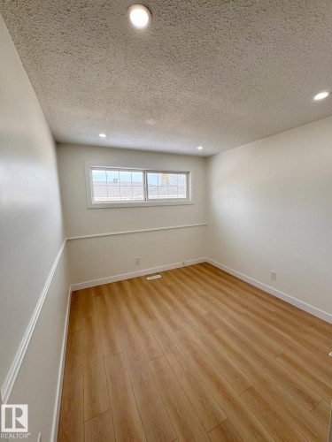 Room featuring wood-finish flooring, white baseboards, and a chair rail - 20 Hunt Road, Edmonton, AB - Indoor Photo Showing Other Room