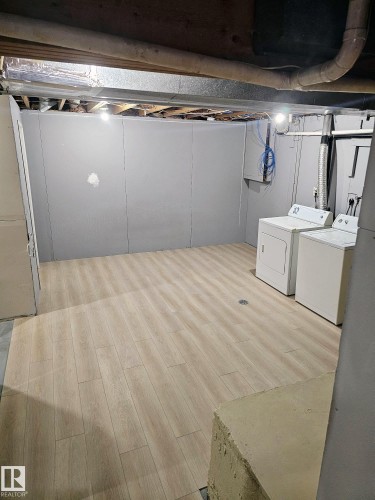 Utility space featuring light wood-finish flooring, exposed ceiling beams, and a floor drain - 20 Hunt Road, Edmonton, AB - Indoor Photo Showing Laundry Room