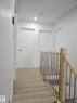Upper-level hallway featuring wood-finish flooring, recessed lighting, and a contemporary wood and metal railing - 20 Hunt Road, Edmonton, AB  - Indoor Photo Showing Other Room 