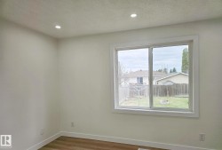Bright interior space featuring a large sliding window with white trim - 