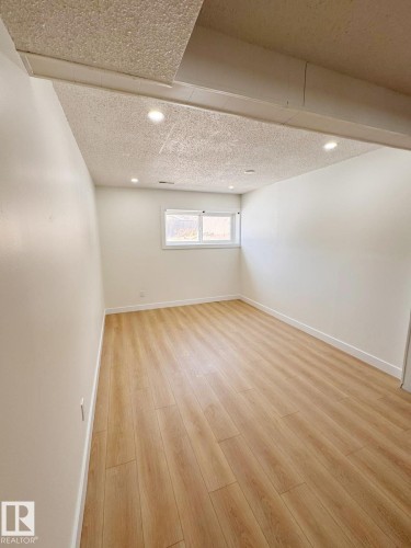 Bright room featuring light wood-finish flooring, white baseboards, and neutral wall paint - 20 Hunt Road, Edmonton, AB - Indoor Photo Showing Other Room