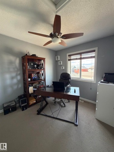 Room featuring a window with horizontal blinds, neutral carpet flooring, and a ceiling fan with integrated lighting - 5204 4 Avenue, Edmonton, AB - Indoor Photo Showing Office