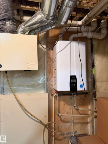 Modern tankless water heater installation - 5204 4 Avenue, Edmonton, AB - Indoor Photo Showing Basement