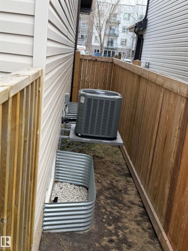 Exterior featuring light-colored horizontal siding, a window well with white gravel, and a central air conditioning unit. - 5204 4 Avenue, Edmonton, AB - Outdoor With Exterior