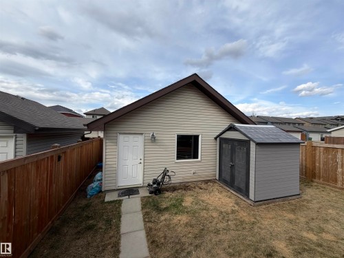 Detached garage with horizontal siding, a side entry door, and an exterior light fixture - 5204 4 Avenue, Edmonton, AB - Outdoor With Exterior