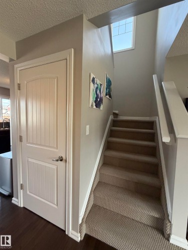 Carpeted staircase featuring a window above, white trim, and a partial balustrade - 5204 4 Avenue, Edmonton, AB - Indoor Photo Showing Other Room