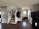 Warm wood-finish flooring extends throughout the entry and living areas - 5204 4 Avenue, Edmonton, AB  - Indoor Photo Showing Other Room 
