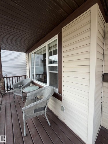 Covered front porch featuring wood-finish decking and a dark brown slatted ceiling - 5204 4 Avenue, Edmonton, AB - Outdoor With Deck Patio Veranda With Exterior