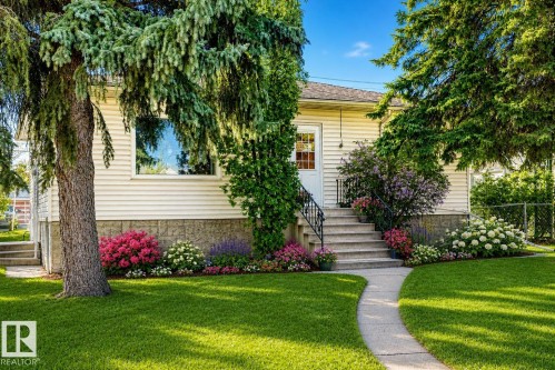 Exterior featuring light-colored siding and a stone foundation - 11424 105 Street, Edmonton, AB - Outdoor