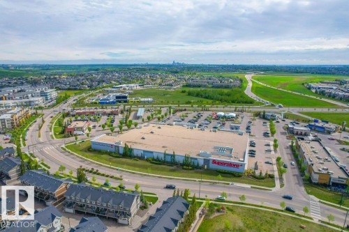 Aerial perspective showcasing a developed commercial and residential area with various buildings - 318 1316 Windermere Way, Edmonton, AB - Outdoor With View