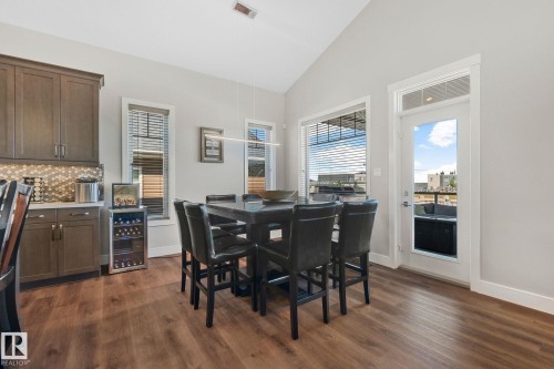 Dining area featuring wood-finish flooring, vaulted ceilings, and a built-in beverage cooler - 67 Enchanted Way Nw, St. Albert, AB - Indoor Photo Showing Dining Room