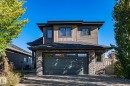 Contemporary facade featuring stacked stone accents, horizontal siding, and a dark asphalt shingle roof - 67 Enchanted Way Nw, St. Albert, AB  - Outdoor 