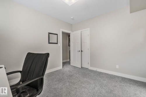 Neutral-toned interior room featuring light gray walls, plush gray carpeting, white trim, and a white paneled door - 67 Enchanted Way Nw, St. Albert, AB - Indoor Photo Showing Other Room