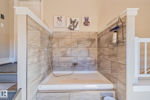 Built-in wash station featuring tiled walls, a white basin, and a handheld showerhead - 67 Enchanted Way Nw, St. Albert, AB - Indoor Photo Showing Bathroom