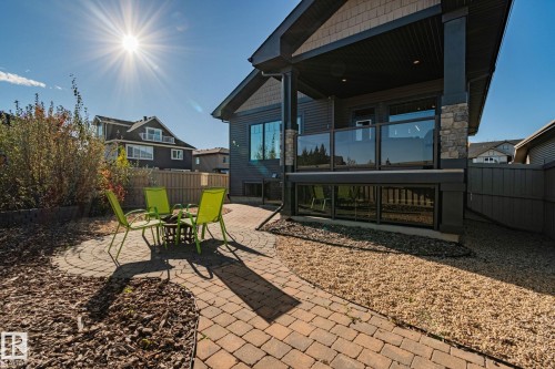 Expansive backyard featuring a circular paver patio, decorative wood mulch landscaping, and a multi-level deck with glass panel railing - 67 Enchanted Way Nw, St. Albert, AB - Outdoor With Deck Patio Veranda