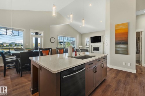 Kitchen island featuring a single-bowl sink, built-in dishwasher, and light-toned countertop - 67 Enchanted Way Nw, St. Albert, AB - Indoor