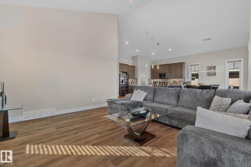 Open-concept living area featuring wood-finish flooring, recessed lighting, and a neutral wall palette - 67 Enchanted Way Nw, St. Albert, AB - Indoor Photo Showing Living Room