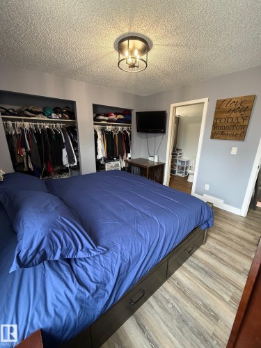 Bedroom featuring light gray walls and wood-finish flooring - 5108 58 Avenue, Elk Point, AB - Indoor Photo Showing Bedroom