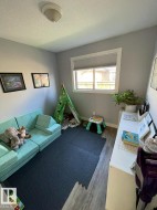 Room featuring wood-finish flooring, light gray wall paint, and a window with a white frame and roller blind - 