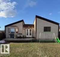 Stucco exterior with a multi-level roofline, featuring a rear wood deck, double glass panel doors, and a bay window - 