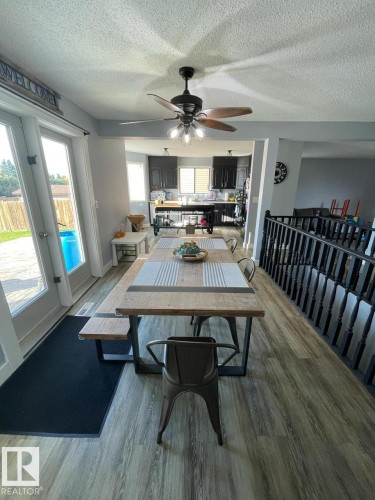 Open-concept living space featuring wood-finish flooring, a contemporary ceiling fan with integrated lighting, and direct outdoor access through double glass patio doors - 5108 58 Avenue, Elk Point, AB - Indoor Photo Showing Dining Room