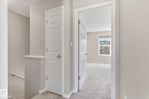 Interior hallway with neutral-toned walls, white trim, and a white panel door - 7114 22 Avenue, Edmonton, AB - Indoor Photo Showing Other Room