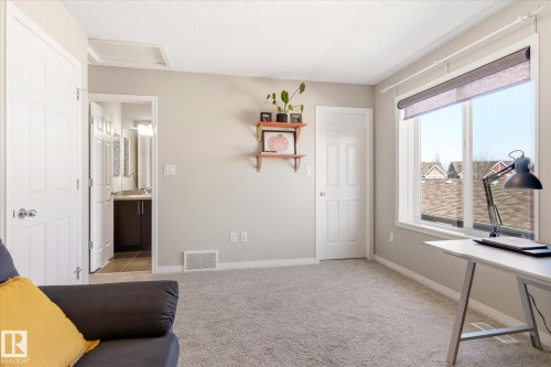 Carpeted room featuring a large window with roller shades, neutral painted walls, and white trim - 7114 22 Avenue, Edmonton, AB - Indoor Photo Showing Other Room