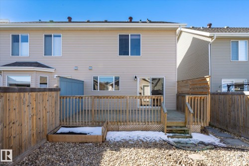 Rear exterior featuring a spacious wooden deck with railings, a built-in planter box, and a gravel ground cover - 7114 22 Avenue, Edmonton, AB - Outdoor With Exterior