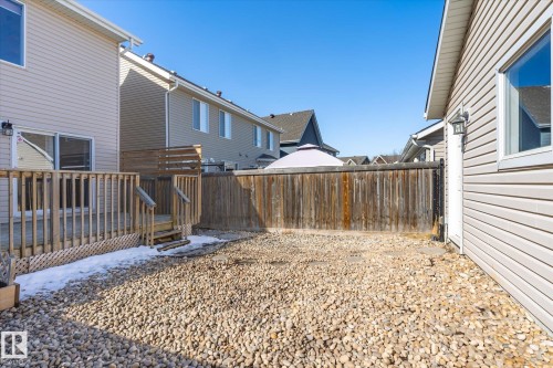 Private backyard featuring a large wood deck with railings and steps, a wood fence, and a gravel ground cover - 7114 22 Avenue, Edmonton, AB - Outdoor With Exterior