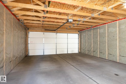 Two-car garage featuring a concrete floor, exposed wood framing, and insulation-ready wall cavities - 7114 22 Avenue, Edmonton, AB - Indoor Photo Showing Garage
