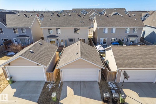 Rear elevation of a two-story residence featuring light-toned siding, multiple windows, and a bay window - 7114 22 Avenue, Edmonton, AB - Outdoor With Exterior