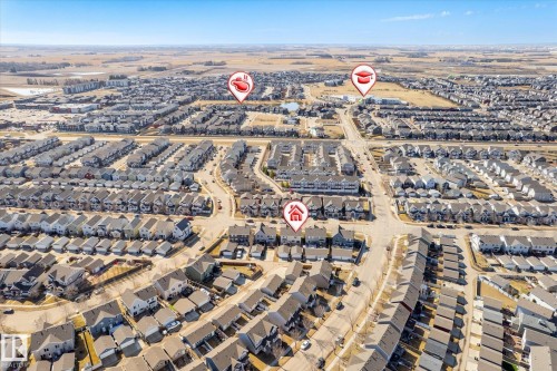 Aerial perspective of a dense residential neighborhood featuring a mix of detached homes and townhomes with dark shingled roofs - 7114 22 Avenue, Edmonton, AB - Outdoor With View