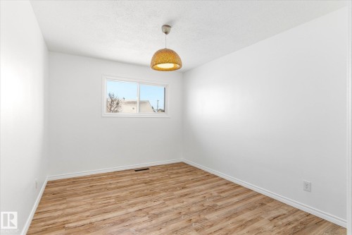 Room featuring light wood-style flooring, white walls, and a contemporary ceiling light fixture - 12823 81 Street, Edmonton, AB - Indoor Photo Showing Other Room