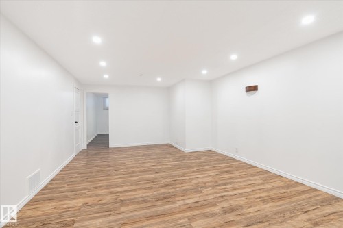 Spacious room featuring light wood-look flooring, white walls, and recessed lighting - 12823 81 Street, Edmonton, AB - Indoor Photo Showing Other Room