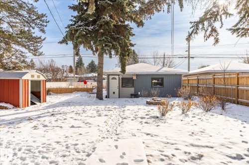The property features a spacious backyard with a red storage shed and a wooden fence - 12823 81 Street, Edmonton, AB - Outdoor
