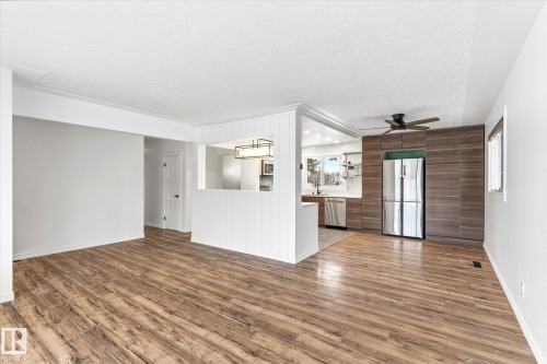 The property features wood-style flooring throughout the open living area - 12823 81 Street, Edmonton, AB - Indoor Photo Showing Other Room