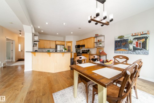 Open-concept living area featuring wood-finish flooring, recessed lighting, and a contemporary chandelier - 1205 Ormsby Lane, Edmonton, AB - Indoor