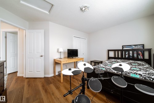 Spacious room featuring wood-finish flooring, white walls, and a ceiling light fixture - 1205 Ormsby Lane, Edmonton, AB - Indoor