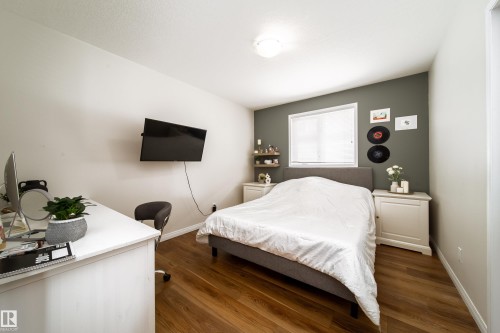 Bedroom featuring wood-finish flooring, a neutral color palette with an accent wall, window with blinds, and recessed lighting - 1205 Ormsby Lane, Edmonton, AB - Indoor Photo Showing Bedroom