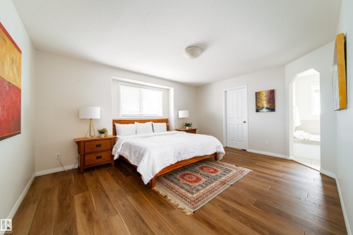 Bright room with wood-finish flooring and a large window with blinds - 1205 Ormsby Lane, Edmonton, AB - Indoor Photo Showing Bedroom