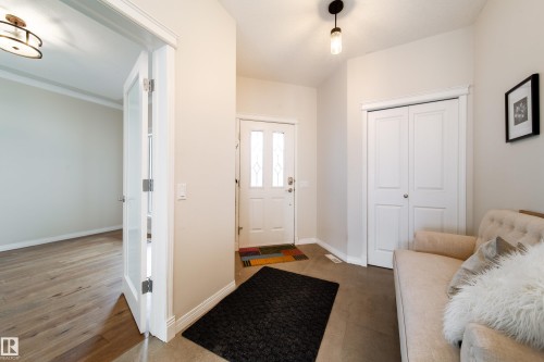 Entryway featuring tile flooring, a white front door with decorative glass inserts, and a bi-fold closet - 1205 Ormsby Lane, Edmonton, AB - Indoor
