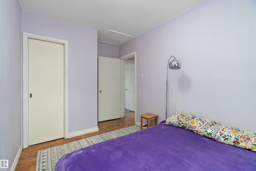 This room features light-toned walls and hardwood style flooring - 7720 85 Avenue, Edmonton, AB - Indoor Photo Showing Bedroom